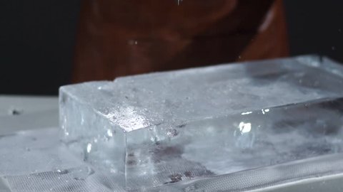 The bartender crushing ice with special fork and breaking off a big piece of ice