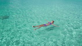 slow motion video of woman floating on tropical water in the Caribbean