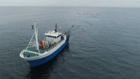 Flying over a Commercial Fishing Ship that Pulls Trawl Net. Shot on Phantom 4K UHD Camera.
