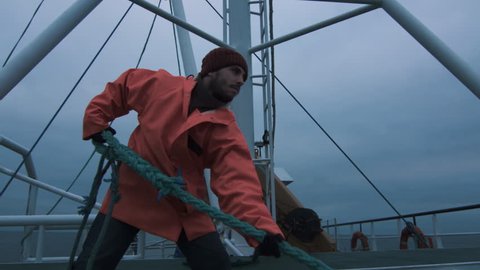 Serious Seaman Pulls the Thick Rope during Traveling on the Ship. Shot on RED Cinema Camera in 4K (UHD).