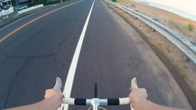 Point-of-view video of person riding a bicycle along the coastline