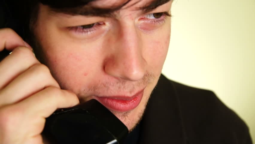 Young man talking on the phone. Closeup on his face.