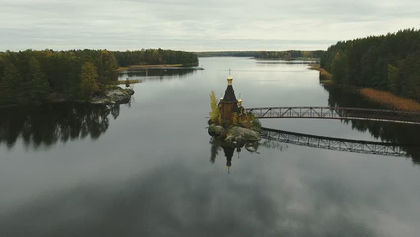 flight over the church, which stands on a small island in the middle of the lake in forest. Russia