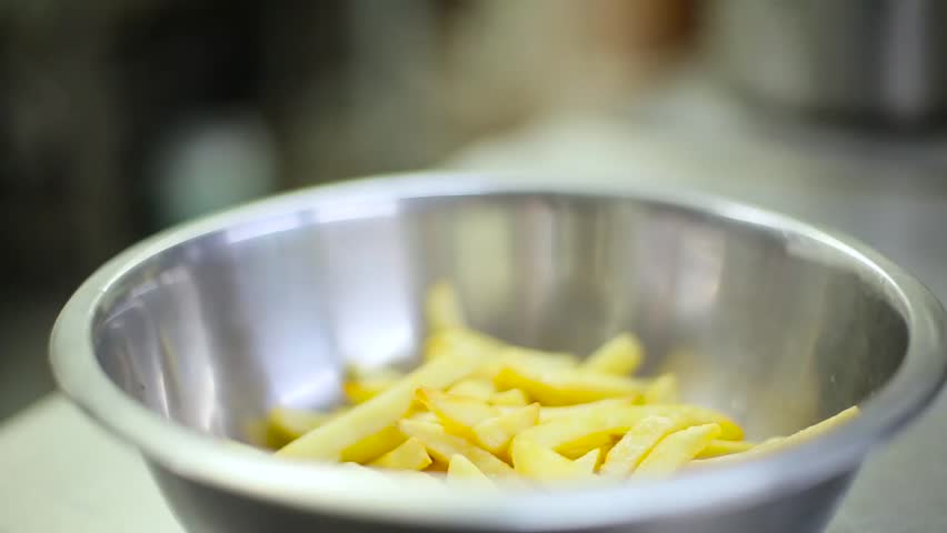 a cook pickles sliced potatoes.