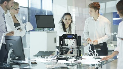 4K Scientific research engineers working in lab with computer and 3D printer (UK-Oct 2016)