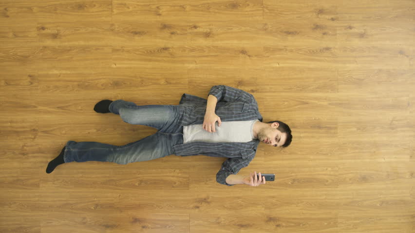 The depressed man lay on the floor and phone. View from above. Real time capture Royalty-Free Stock Footage #21853099