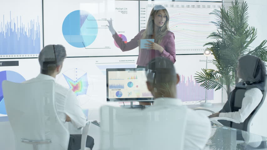 4K Businesswoman giving presentation to colleagues in modern office (UK-Oct 2016)