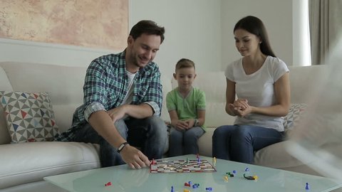 Family at home playing board game