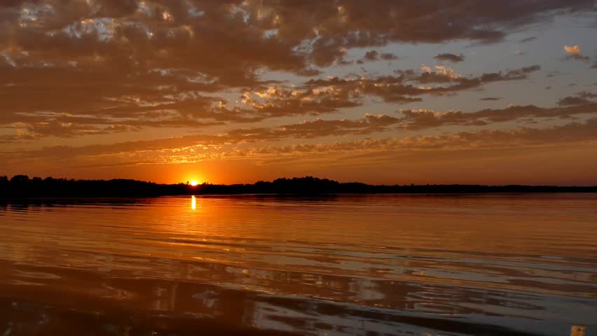 Sunset over Lake Irving, the first lake on the Mississippi River, in Bemidji, Minnesota - 30 second 4K footage with slight zoom in and down