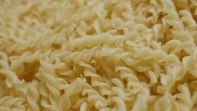 Falling on top pieces of famous Italian food pile slow-mo 1920X1080 HD footage - Slow motion fall on table corkscrew shaped pasta close-up 1080p FullHD tilting video
