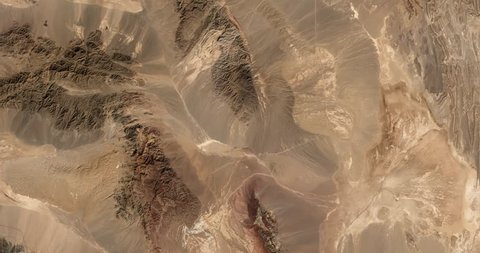 High-altitude overflight aerial of rocky desert in the  Yazd and Khorasan provinces of Iran. Clip loops and is reversible. Elements of this image furnished by NASA 