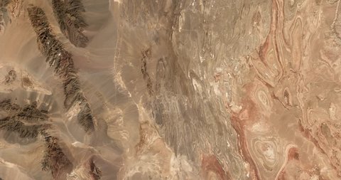 High-altitude overflight aerial of rocky desert in the  Yazd and Khorasan provinces of Iran. Clip loops and is reversible. Elements of this image furnished by NASA 