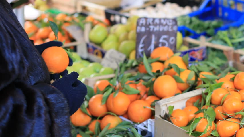 Woman buys oranges at Italian market