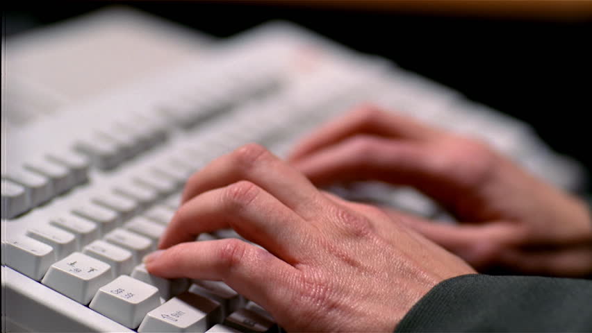 Closeup of man's hands typing on a keyboard