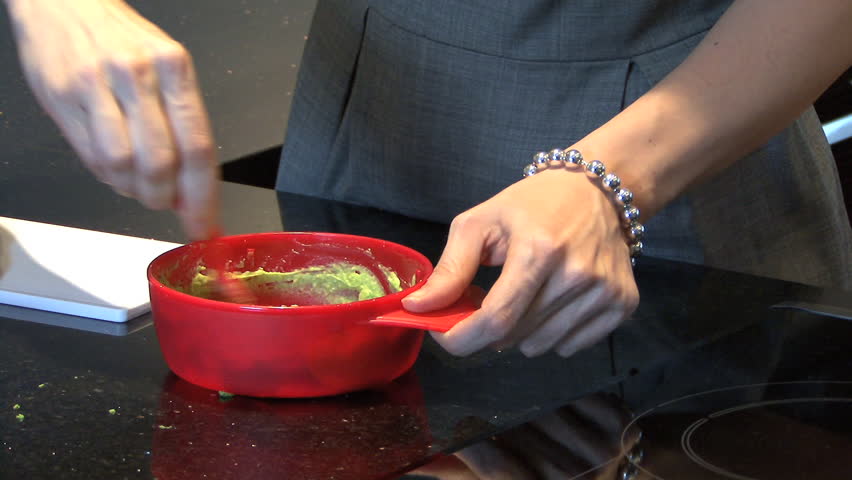 CLOSE UP PAN OF A WOMAN PREPARING BABY FOOD