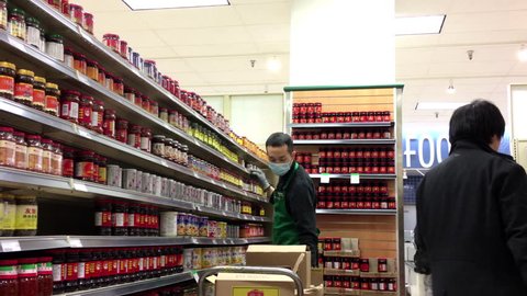 Burnaby, BC, Canada - November 29, 2016 : Grocery clerk stocking food for sale inside T&T Chinese supermarket with 4k resolution