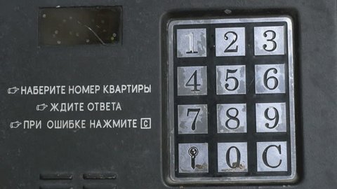 The person opening the entrance door using a numeric code of access. Text on the control panel Dial the number of the apartment. Wait for a response. During the error push the C