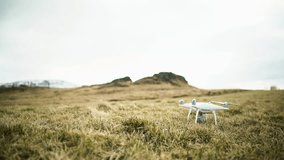 Dolly shot of quadcopter flying over grassy landscape in Iceland

