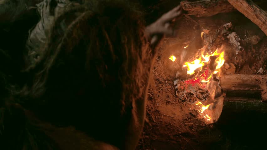 Neanderthal man warms his hands by the first bonfire in his cave Royalty-Free Stock Footage #21903112