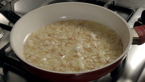 Close-up  -  chopped onion is fried in oil in a frying pan