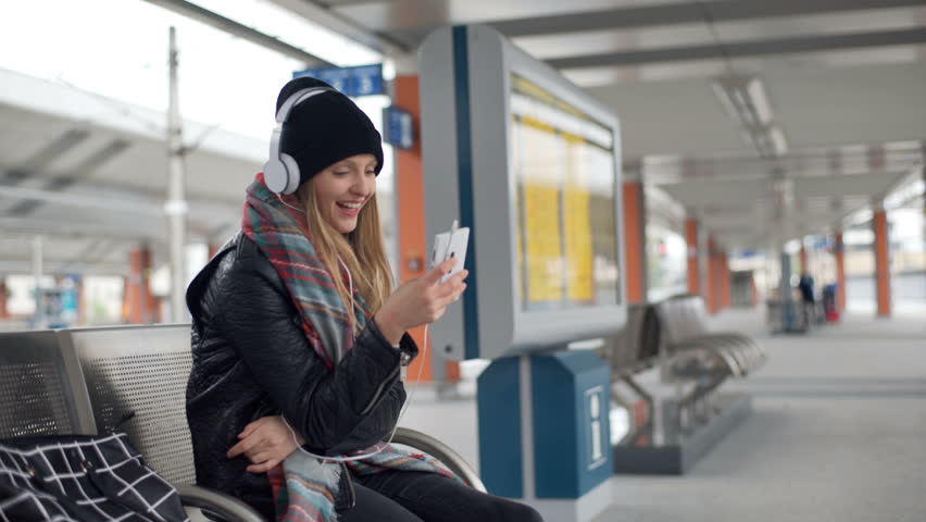 Girl looking very happy while texting on smartphone and listening music

