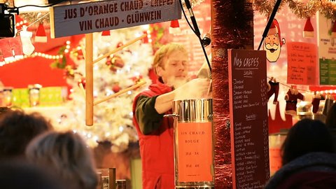 STRASBOURG, FRANCE - CIRCA 2016: Man preparing mulled wine from organic ingredients at Christmas Market waiting for customers