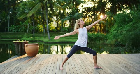 Woman practicing yoga outdoors on beautiful deck