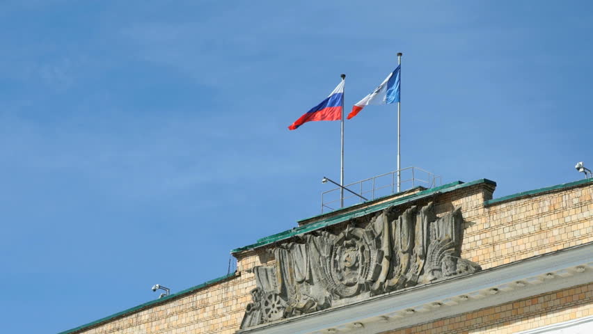 Administrative building with waving flags of Russia and Velikiy Novgorod