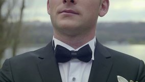 Closeup of groom's suit and bow tie.