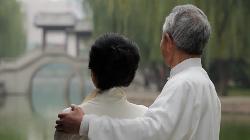 MS Rear view of mature couple looking at bridge and lake in park / Beijing, China