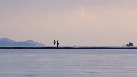 Two young girls enjoy walking on the float bridge at sunrise.