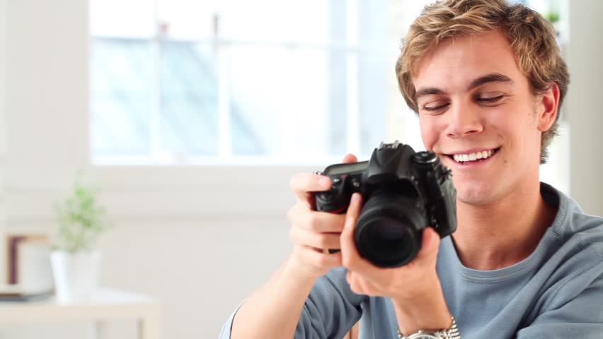 Attractive young man taking photographs with dslr digital camera at home | Shutterstock HD Video #2192332