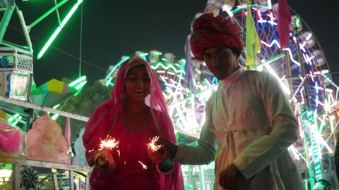 Indian couple in traditional dress with fire sparkle cracker at Diwali Mela festival in India  스톡 비디오
