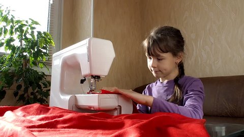 The child learns to sew on the sewing machine. Full hd