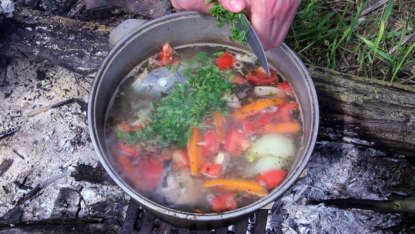 pot with fish soup, fish soup on fire outside