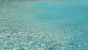 Aquamarine surface of water in pool with  fountain. Many drops of water falling down. Real time full hd video footage.