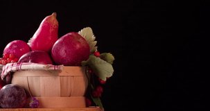 Still life fruits composition rotation 4k looped video intro copy space. Red food in basket isolated on black background
