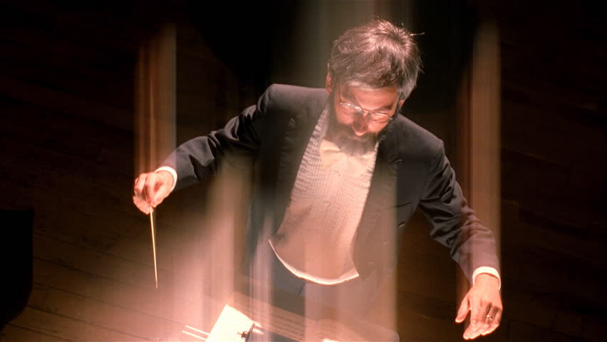 Orchestra conductor waves baton