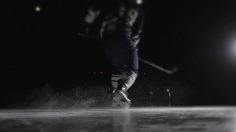 Ice hockey player shoots the puck, power slap shot in canadian style by professional athlete.