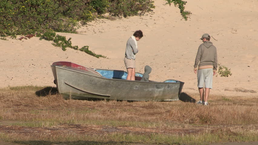 Parents lifting their child out of a boat