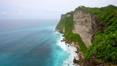 Waves of the Indian Ocean break about coastal rocks. Bali. Indonesia
