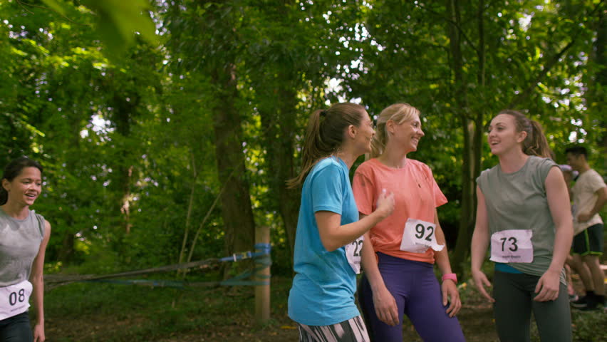 4K Smiling female competitors in muddy endurance contest pose for a photo (UK-Oct 2016)