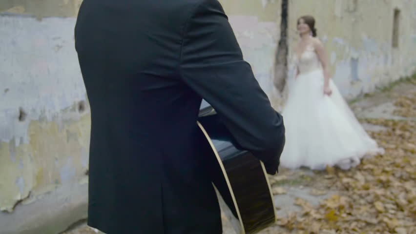 Groom playing guitar for his bride
