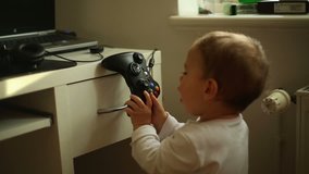 Cute, toddler baby boy playing a computer game pad
