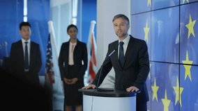 4K Politician making a speech at press conference, EU flag in background (UK-Oct 2016)