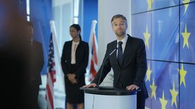 4K Politician making a speech at press conference, EU flag in background (UK-Oct 2016)