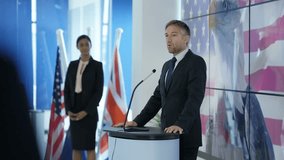 4K Politician making a speech at press conference, american flag in background (UK-Oct 2016)