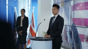 4K Politician making a speech at press conference, american flag in background (UK-Oct 2016)