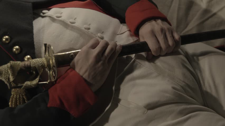 VIRGINIA - SUMMER 2015 - Reenactment of Death of General Napoleon Bonaparte in 1831 - dying in exile on St. Helena Island.  In full military uniform with sword and medals on his chest.  Close details.