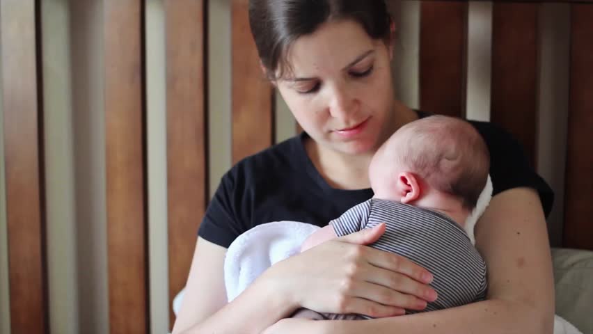 A young mother holding her beautiful newborn baby boy
